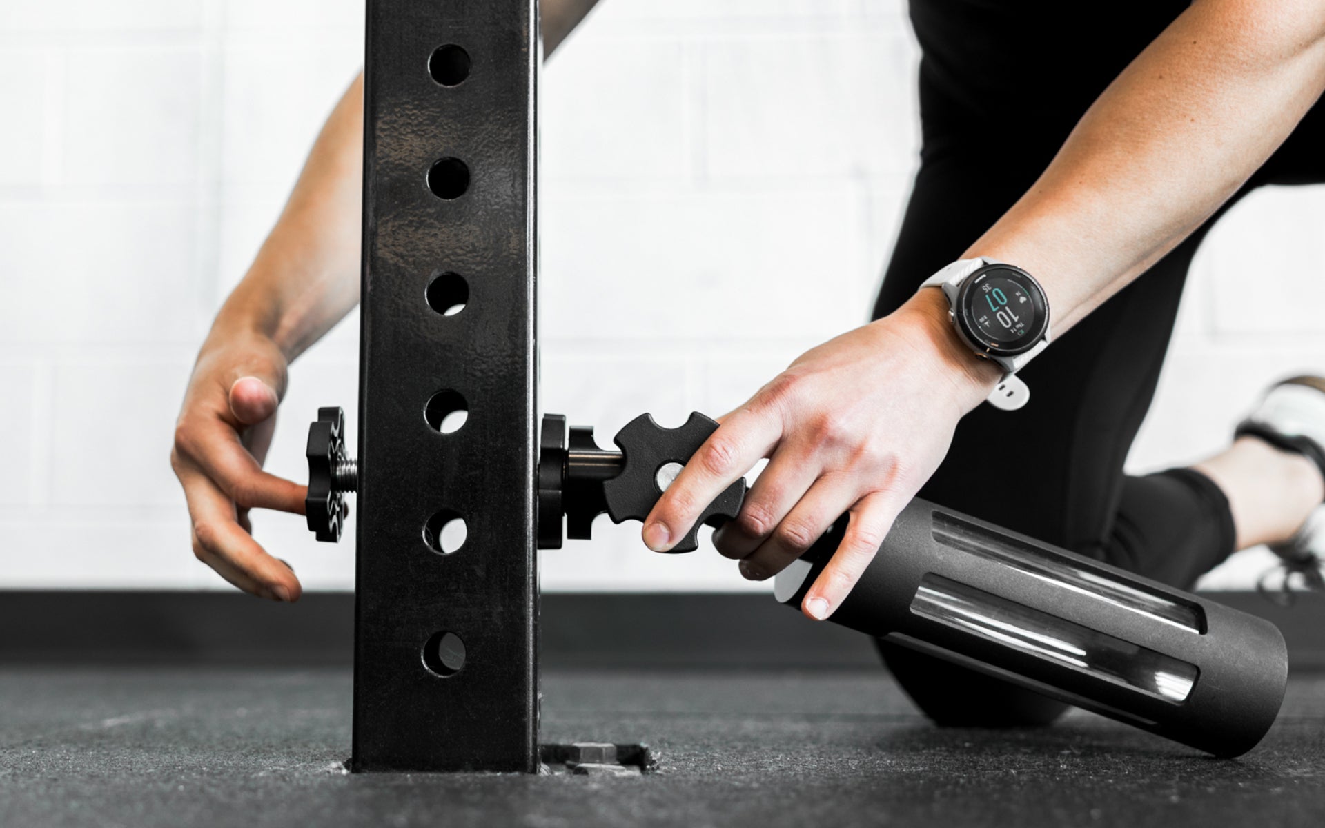 An athlete installing the base of the Rack Mounted REP® x Kleva Built® Adroit Landmine on a 4000 series rack