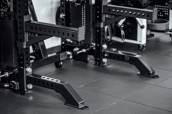 Close-up of a weightlifting rack in a gym setting with Front Foot Extension Pair 2.0

